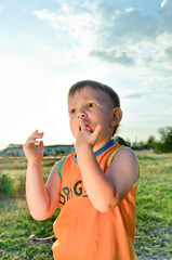 Young boy eating a stick of cotton candy