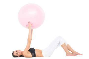 Fototapeta na wymiar Portrait of a fit woman exercising with fitness ball
