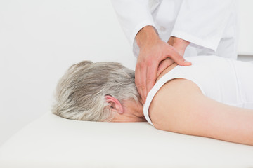 Physiotherapist massaging a senior woman's back