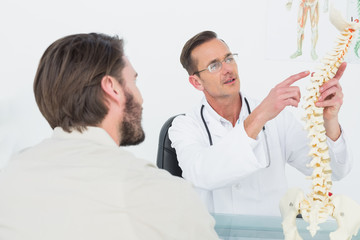 Male doctor explaining the spine to a patient