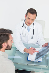 Male doctor explaining spine x-ray to patient