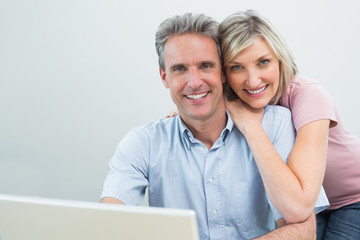 Content couple using laptop at home