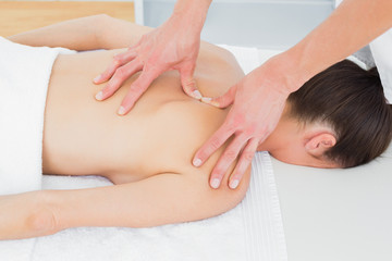 Physiotherapist massaging woman's back