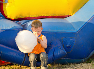 Cute small boy enjoying a stick of candy floss