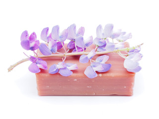 soap and flowers on white background