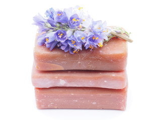 soap and flowers on white background