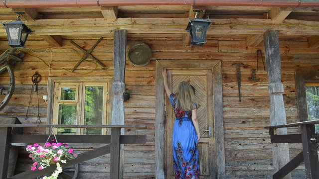 woman looking key over old house wooden door frame