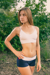 Fototapeta premium Beautiful young blonde woman in white tank top and denim shorts