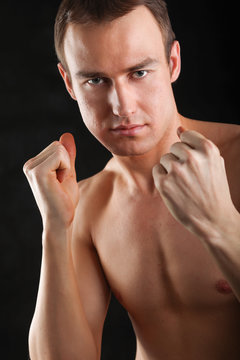 Portrait of boxer on black background.