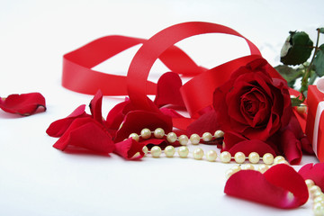 fine pearl beads and red roses petals.