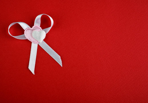 White bow with hearts on a red background