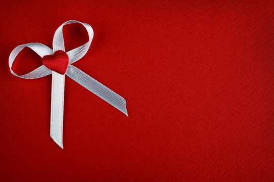 White bow with heart on a red background