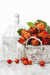 Basket of orange roses and white victorian birdcage