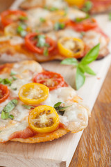 Mini pizzas with mozzarella, cherry tomatoes and basil