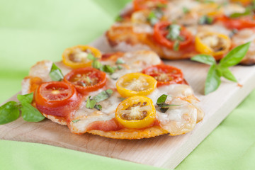 Mini pizzas with mozzarella, cherry tomatoes and basil