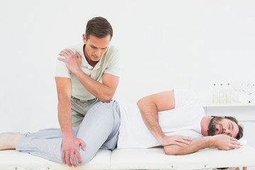 Fototapeta na wymiar Male physiotherapist examining a young man