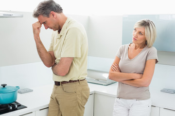 Angry couple after a fight in kitchen