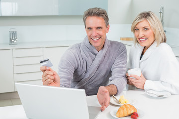 Fototapeta na wymiar Couple doing online shopping in kitchen