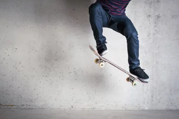 Rolgordijnen Skateboarder doing a skateboard trick - ollie - against concrete © pio3