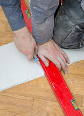 Male hands measuring and cutting gypsum plasterboard