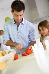 Man in kitchen preparing lunch with daughter