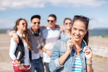 teenage girl with headphones and friends outside