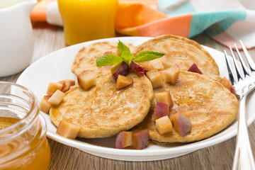 Breakfast with pancakes, peaches and honey, close-up