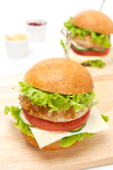 chicken burger with vegetables, cheese on a wooden board