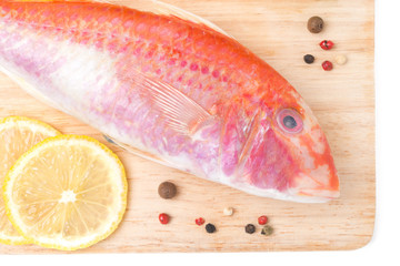 fresh surmullet, lemon and spices on a cutting board close-up