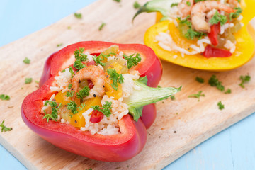 stuffed peppers with salad of rice and shrimp on a wooden board