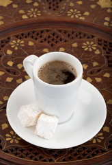 Cup of black turkish coffee on the vintage wooden table.