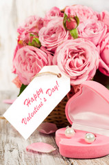 Pink roses and gift in a basket