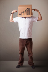 Young man gesturing with a cardboard box on his head with diagra