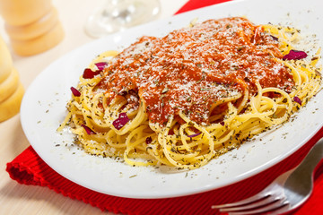 Pasta with sauce and parmesan cheese on table