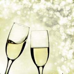Glasses with champagne over holiday background