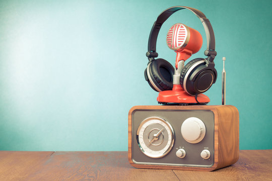 Retro radio, red microphone, headphones on table old style photo