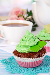 Beautiful cupcakes on dining table on room background
