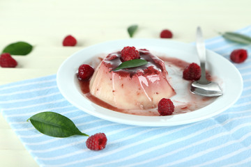 Panna Cotta with raspberry sauce, on wooden background