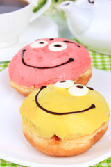 Sweet donuts with cup of tea on table close-up