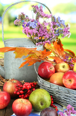 Juicy apples in basket on table on natural background