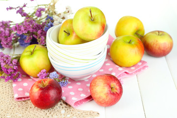Juicy apples on plate on white wooden table