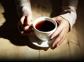 Hands holding mug of hot drink, close-up