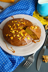 Delicious pumpkin pie on plate on wooden table close-up