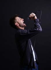 Young musician singing, on gray background