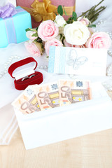 Euro banknotes as gift at wedding on wooden table close-up