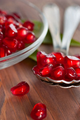 Fresh pomegranate seeds in a spoon.