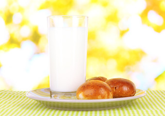 Bread roll and glass of milk on nature background