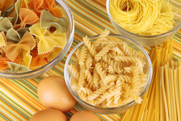 Different types of pasta on striped tablecloth