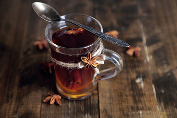 Hot beverage in glass cup with fruits and spices,