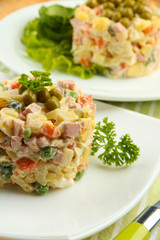 Russian traditional salad Olivier, on wooden background